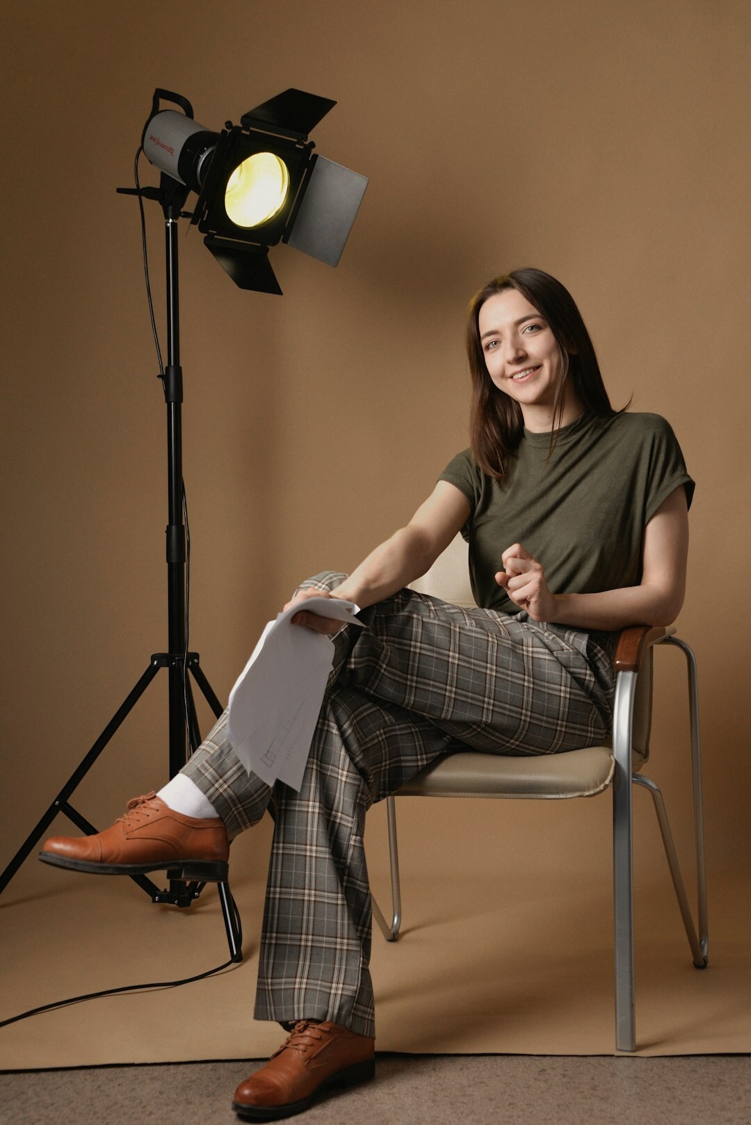 Portrait of a Belgian television presenter holding notes and smiling